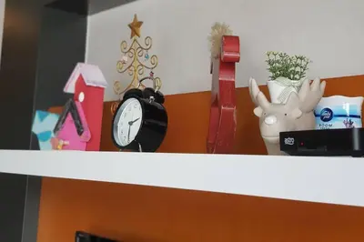 a shelf with a clock and other items on it at Cameron Square, Nova Highlands - 1BR Studio Suite in Brinchang