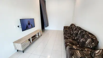 a living room with a couch and a tv at Homestay LK in Sitiawan