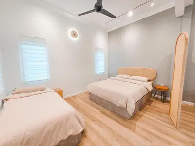 two beds in a room with white walls and wood floors at Spacious Corner Landed House Golden Hills Night Market in Brinchang