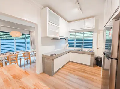 a kitchen with white cabinets and a table and chairs at Spacious Corner Landed House Golden Hills Night Market in Brinchang