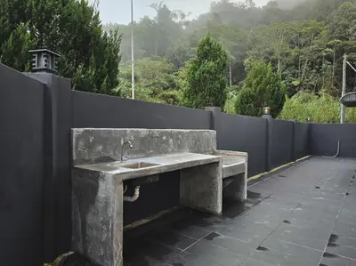 a concrete sink on a wall with a fence at Spacious Corner Landed House Golden Hills Night Market in Brinchang