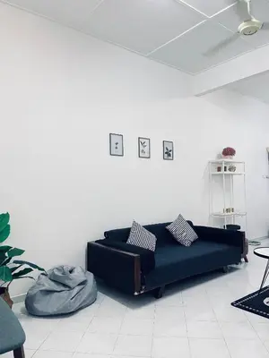 a living room with a black couch in a white room at Comfort Semi D House, 1 min to Town by Mr Homestay in Teluk Intan