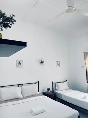 two beds in a room with white walls at Comfort Semi D House, 1 min to Town by Mr Homestay in Teluk Intan