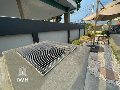 a metal grate on a table with an umbrella at Ipoh 19A Villa for 12pax 6 Carpark with BBQ by IWH in Ipoh