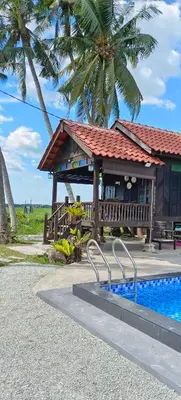 a resort with a swimming pool next to a building at Kampung Cheq Homestay - Private Pool, Free Wifi, Netflix in Penaga
