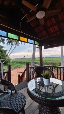 a patio with a table and chairs on a deck at Kampung Cheq Homestay - Private Pool, Free Wifi, Netflix in Penaga