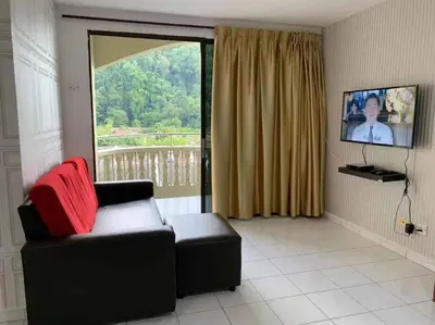 a living room with a couch and a large window at Pangkor Island CoralBay Private Apartment in Pasir Bogak