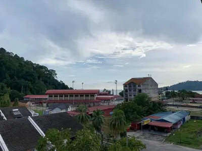 a group of buildings with palm trees in a city at Pangkor Island CoralBay Private Apartment in Pasir Bogak