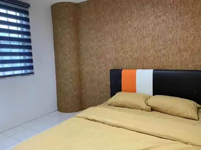 a bedroom with a bed with an orange and white headboard at Pangkor Island CoralBay Private Apartment in Pasir Bogak