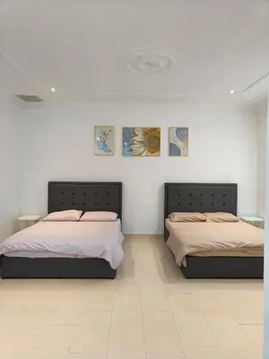 two beds in a room with white walls at Pangkor Island Seaside @ 4 rooms Homestay in Pasir Bogak