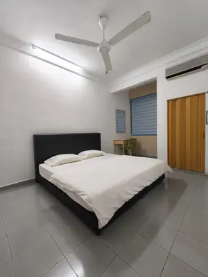 a bedroom with a large bed with a ceiling fan at Pangkor Island Seaside @ 4 rooms Homestay in Pasir Bogak