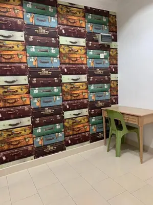 a table and a green chair in front of a wall at Pangkor Island Seaside @ 4 rooms Homestay in Pasir Bogak