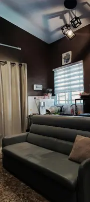 a couch in a living room with a window at Studio Teratak Alisha Permatang Pauh in Permatang Pauh