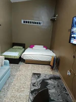 a room with two beds and a flat screen tv at Studio Teratak Alisha Permatang Pauh in Permatang Pauh