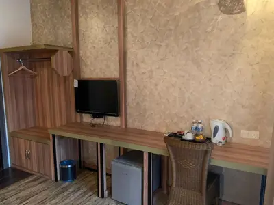 a room with a desk with a television and a table at I Garden Hotel in Ipoh