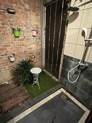 a patio with a table and a chair on grass at I Garden Hotel in Ipoh