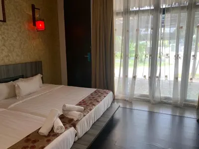 a bedroom with two beds and a large window at I Garden Hotel in Ipoh