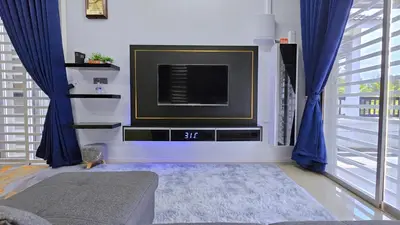 a living room with a tv and blue curtains at Homestay By MSH Seri Iskandar in Seri Iskandar