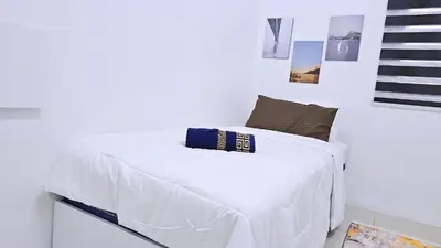 a white bedroom with a white bed with a pillow on it at Homestay By MSH Seri Iskandar in Seri Iskandar