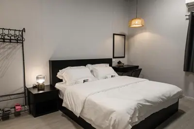a bedroom with a large bed with white sheets and pillows at FAST FIVE At Gurney in Tanjong Tokong