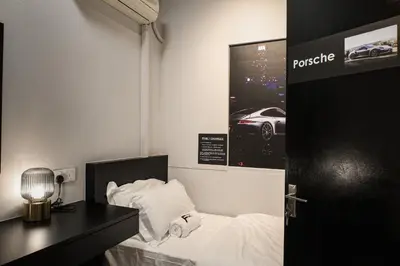 a room with a bed and a desk and a car poster at FAST FIVE At Gurney in Tanjong Tokong