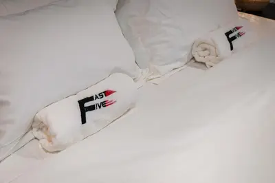 a white bed with two pillows with the words no fire at FAST FIVE At Gurney in Tanjong Tokong