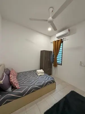 a bedroom with a bed and a ceiling fan at Mikhail's Homestay in Sungai Petani
