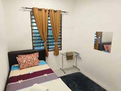a bedroom with a bed and a window at Mikhail's Homestay in Sungai Petani