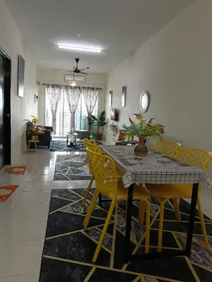 a dining room with a table and yellow chairs at Homestay Kak Ninie in Teluk Intan