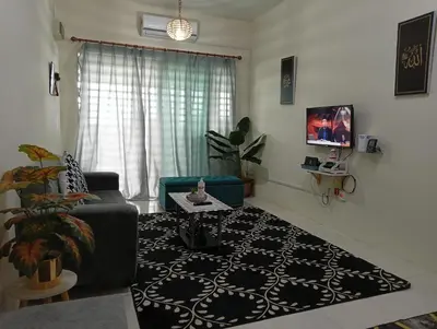 a living room with a couch and a table at Homestay Kak Ninie in Teluk Intan