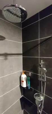 a black tiled bathroom with a sink and a shower at H&W Sunway Onsen Suite Tambun Sunway City Ipoh in Ipoh