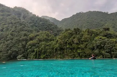 a person in a pool of water with mountains in the background at H&W Sunway Onsen Suite Tambun Sunway City Ipoh in Ipoh