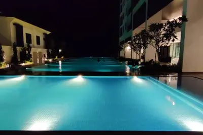 a large swimming pool at night with blue lights at H&W Sunway Onsen Suite Tambun Sunway City Ipoh in Ipoh