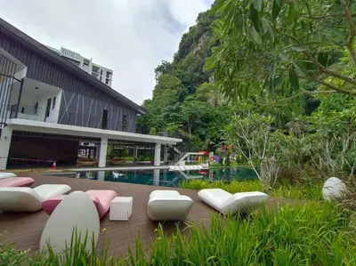 a patio with chairs and a pool in front of a building at be.Bamboo The Cove-6mins Lost World Tambun-10pax in Ipoh