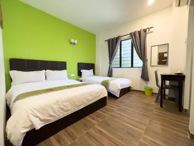 a bedroom with two beds and a green wall at Inn Residence 18 in George Town