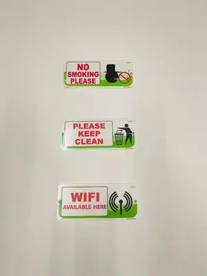 a group of signs on a white wall at AK Greenrise Meru in Ipoh