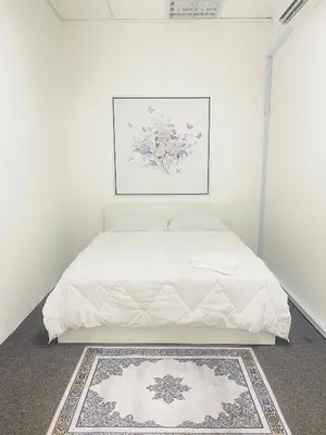 a bedroom with a white bed with a painting on the wall at AK Greenrise Meru in Ipoh