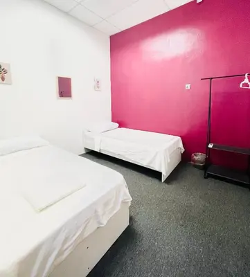 two beds in a room with a pink wall at AK Greenrise Meru in Ipoh