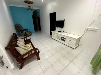 a living room with a chair and a television at Manjung Cozy Homestay in Sitiawan