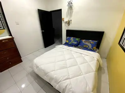 a bedroom with a large white bed with blue pillows at Manjung Cozy Homestay in Sitiawan