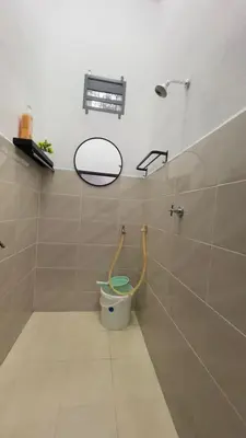 a bathroom with a toilet and a mirror on the wall at Tok Abah Homestay Bukit Mertajam in Bukit Mertajam