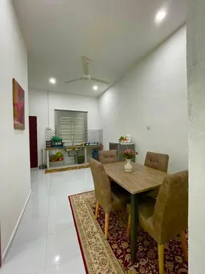 a living room with a wooden table and chairs at Tok Abah Homestay Bukit Mertajam in Bukit Mertajam