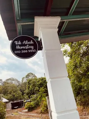a sign on the side of a house with a pillar at Tok Abah Homestay Bukit Mertajam in Bukit Mertajam