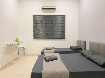 a room with three beds and a window with a shutter at Warm and Cozy in Teluk Intan