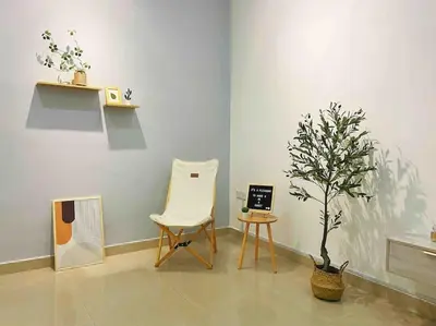 a room with a chair and a tree in it at Warm and Cozy in Teluk Intan