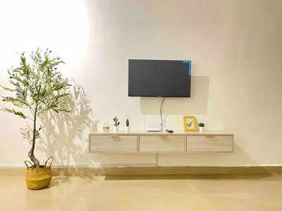 a living room with a television on a white wall at Warm and Cozy in Teluk Intan