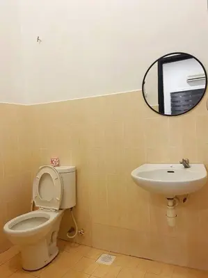 a bathroom with a toilet and a sink at Warm and Cozy in Teluk Intan