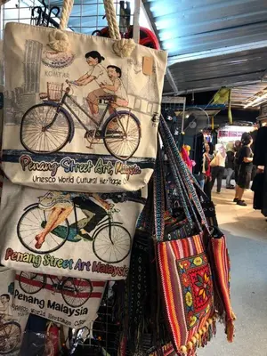 a bunch of bags hanging in a market with a bike at New! Batu Ferringhi Seaview Cozy Condo, Penang in Batu Ferringhi