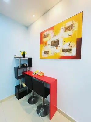 a room with a red table and a painting on the wall at KawanMu House with 6 Bedrooms in Taiping