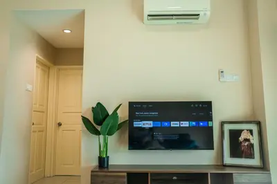 a flat screen tv on a wall with a plant at Stylish River-View Apartment In Ipoh in Ipoh